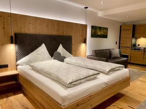 1 dormitorio con 1 cama grande y 1 silla en Chalet & Almhostel Alpenperle - Selbstversorger Unterkunft, en Tannheim