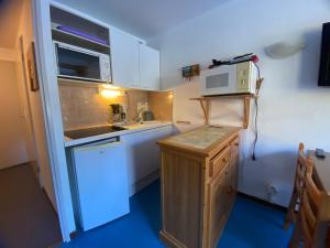 a small kitchen with a stove and a microwave at Studio Morillon 1100, 1 pièce, 4 personnes - FR-1-642-75 in Morillon