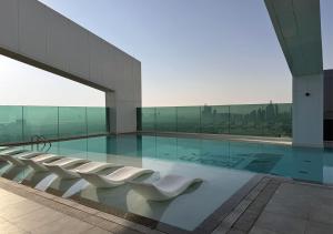 a building with a swimming pool with white chairs at Dubai Frame view, 5 mins to Burj Khalifa in Dubai