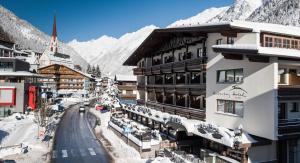 un lodge de ski dans les montagnes avec de la neige au sol dans l'établissement Hotel Hubertus inklusive Summercard, à Sölden