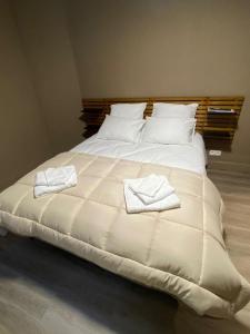 ein großes weißes Bett mit zwei Handtüchern darauf in der Unterkunft Chez Mo in La-Roche-en-Ardenne