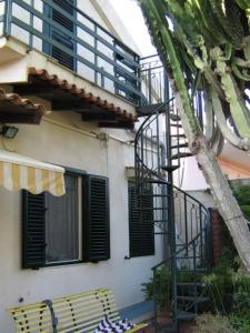 un edificio con scala accanto a un edificio con albero di Mora apartment 1st floor near the sea - Climate and wi-fi ad Avola
