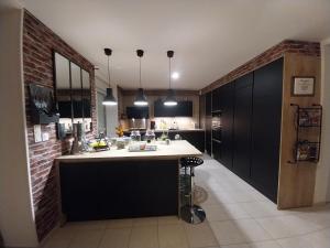 een keuken met zwarte kasten en een wit aanrecht bij Relais Du Boss in Saint-Vran
