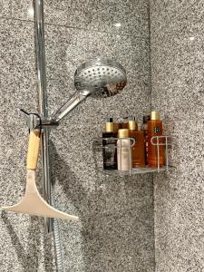 a shower with a shower head and a shelf with medicines at Le Studio Grimaldi in Ostend