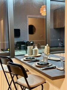 a kitchen with a table with plates and glasses on it at Le Studio Grimaldi in Ostend