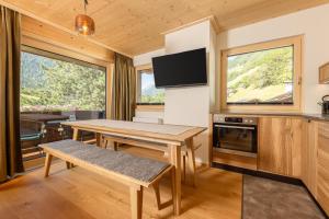 a living room with a wooden table and a tv at Pension Gulla - Ferienhaus Appartements B&B in Neustift im Stubaital