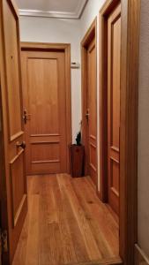 an empty hallway with two doors and wooden floors at Sol y Nieve Campoo in Reinosa