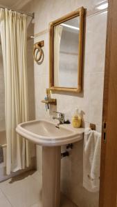 a bathroom with a sink and a mirror at Sol y Nieve Campoo in Reinosa