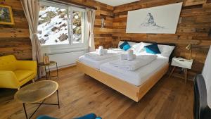 Mattertal Lodge في Embd: غرفة نوم بسرير وكرسي اصفر ونافذة