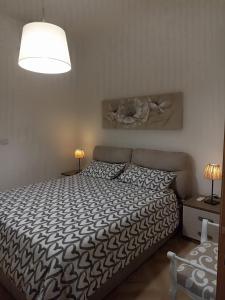 una camera da letto con un letto con un piumone bianco e nero di Casa Rossi a Pomigliano dʼArco