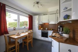 uma cozinha com armários brancos e uma mesa de madeira em Ferienhaus Windschäufeln in Garmisch-Partenkirchen em Garmisch-Partenkirchen