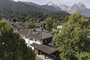 um grupo de casas com montanhas ao fundo em Ferienhaus Windschäufeln in Garmisch-Partenkirchen em Garmisch-Partenkirchen