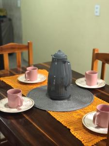a table with plates and cups and a pot on it at Casa vila costeira. in Camocim