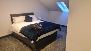 1 dormitorio con 1 cama con manta azul en Homestay by BIC Oates 9 en Dewsbury