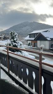 ヴィンターベルクにあるGemütlicher Ferienwohnung in Niedersfeld bei Winterberg, kostenloses WLANの雪に覆われた柵と家のあるバルコニー