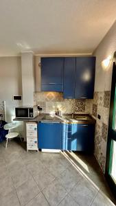una cocina con armarios azules y fregadero en Agriturismo Azzurra Biricchina, en Riva Ligure