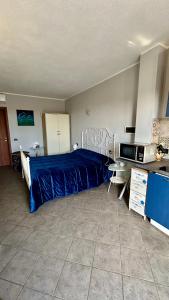 1 dormitorio con 1 cama azul y microondas en Agriturismo Azzurra Biricchina, en Riva Ligure