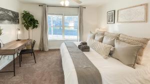 a bedroom with a bed with a desk and a window at 5 mins to Speedway! Walk to Zoo, WR park, IUPUI! in Indianapolis +26 photos