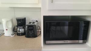 a microwave sitting on a counter next to a coffee maker at Lagoon Rd Unit 4 in DʼArbeau