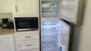 an empty refrigerator with its door open in a kitchen at Lagoon Rd Unit 4 in DʼArbeau