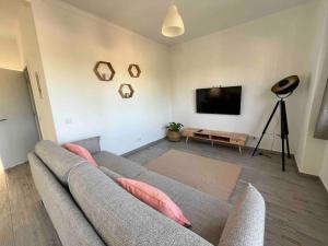 Sintra Sweet Apartment III - Free Parking في سينترا: غرفة معيشة مع أريكة وتلفزيون بشاشة مسطحة