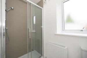 um chuveiro com uma porta de vidro na casa de banho em Elgin, home from home em Elgin