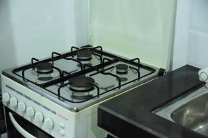 a stove top oven in a kitchen next to a sink at GK Home Stay in Hikkaduwa