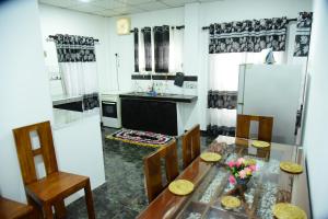 a kitchen with a dining table and a refrigerator at GK Home Stay in Hikkaduwa