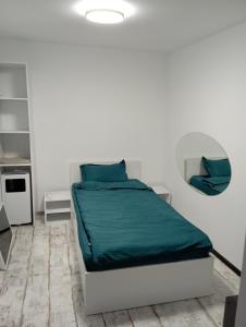 - une chambre blanche dotée d'un lit avec des draps verts dans l'établissement PENSIUNE Sweet Touch, à Craiova