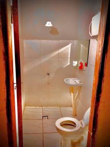 a small bathroom with a toilet and a sink at La escala aeropuerto in Luque