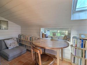ein kleines Zimmer mit einem Holztisch und Bücherregalen in der Unterkunft Penty Ty Gwen (Cap de la Chèvre) in Crozon