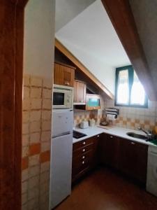 a kitchen with a white refrigerator and a sink at Arrabal de Santa María in Sigüenza