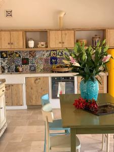 a kitchen with a table with a vase of flowers on it at Trullo il Gatto Nero in Ostuni