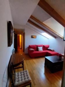 西古恩薩的住宿－Arrabal de Santa María，客厅配有红色的沙发和桌子