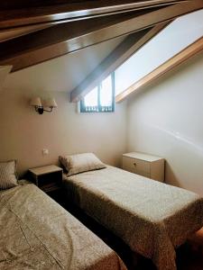 a bedroom with two beds and a window at Arrabal de Santa María in Sigüenza