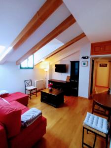 西古恩薩的住宿－Arrabal de Santa María，客厅配有红色沙发和电视