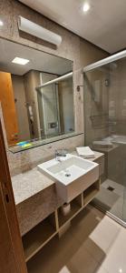 a bathroom with a sink and a mirror and a shower at Flat particular no Hotel Jade Park Sul Brasília B812 in Brasilia