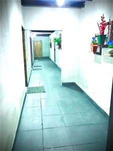 korytarzem z podłogą wyłożoną kafelkami w budynku w obiekcie La escala aeropuerto w mieście Luque