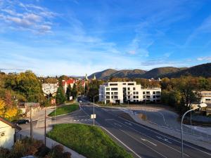 une rue vide dans une ville avec des bâtiments et des montagnes dans l'établissement Al Corso Pension, à Banská Bystrica
