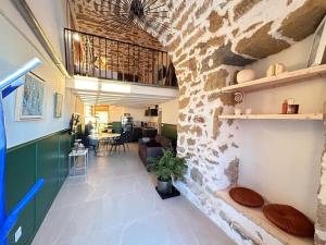 a living room with a stone wall at Eden de Thau 1ère ligne in Bouzigues