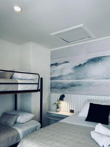 a bedroom with two bunk beds and a painting of the ocean at Yogi hostel boutique in Santiago