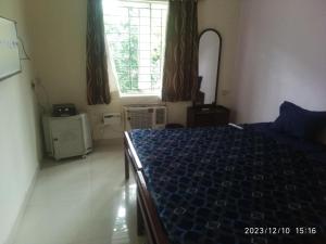 a bedroom with a blue bed and a window at Royale Seaward Cozy Suite in Chennai