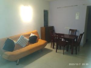 uma sala de estar com um sofá e uma mesa em Royale Seaward Cozy Suite em Chennai
