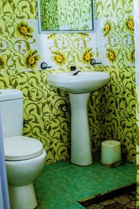 een badkamer met een wit toilet en een wastafel bij Sanasuma Hotel in Hambantota