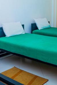two beds sitting next to each other in a room at Sanasuma Hotel in Hambantota