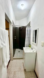 a white bathroom with a shower and a sink at Confortable Loft MN 960 D Centro Mty cerca de todo in Monterrey