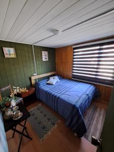 una camera con letto blu di hospedaje a Puerto Varas