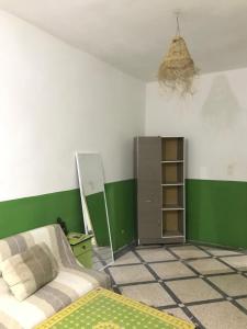 a bedroom with a bed and a green and white wall at Green IGR Guesthouse in Agadir