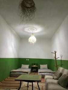 a living room with a couch and a chandelier at Green IGR Guesthouse in Agadir