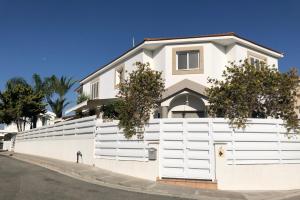 een wit hek voor een huis bij Villa Andy-350 m from the beach in Larnaka